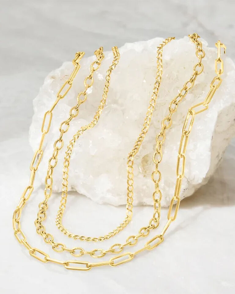 Three Yellow Gold Link Necklaces on a White Granite Stone